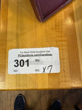 Wooden dining table with sticker showing auction lot 301, bid quantity x7. Smooth finish, rich grain.