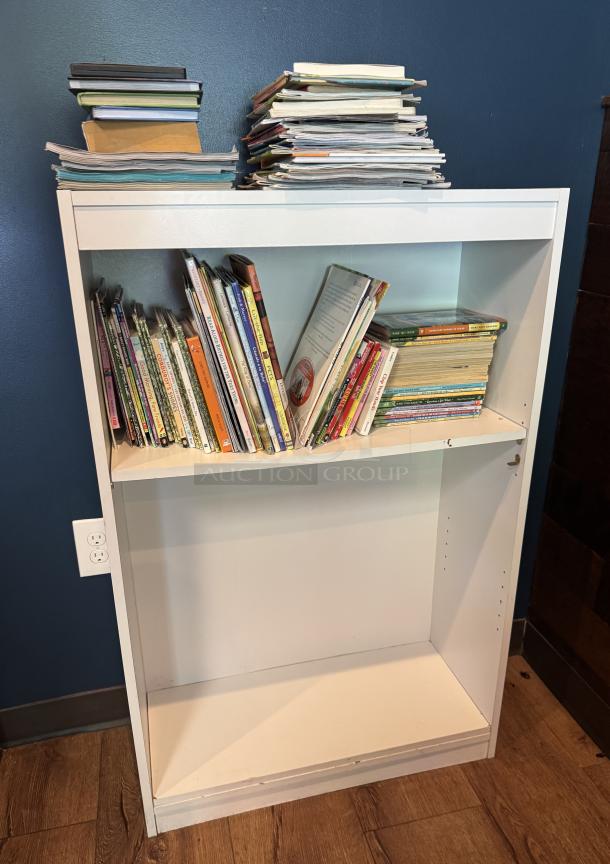 White bookcase with two shelves filled with various books. Slight wear visible on shelves. Perfect for home or office use.