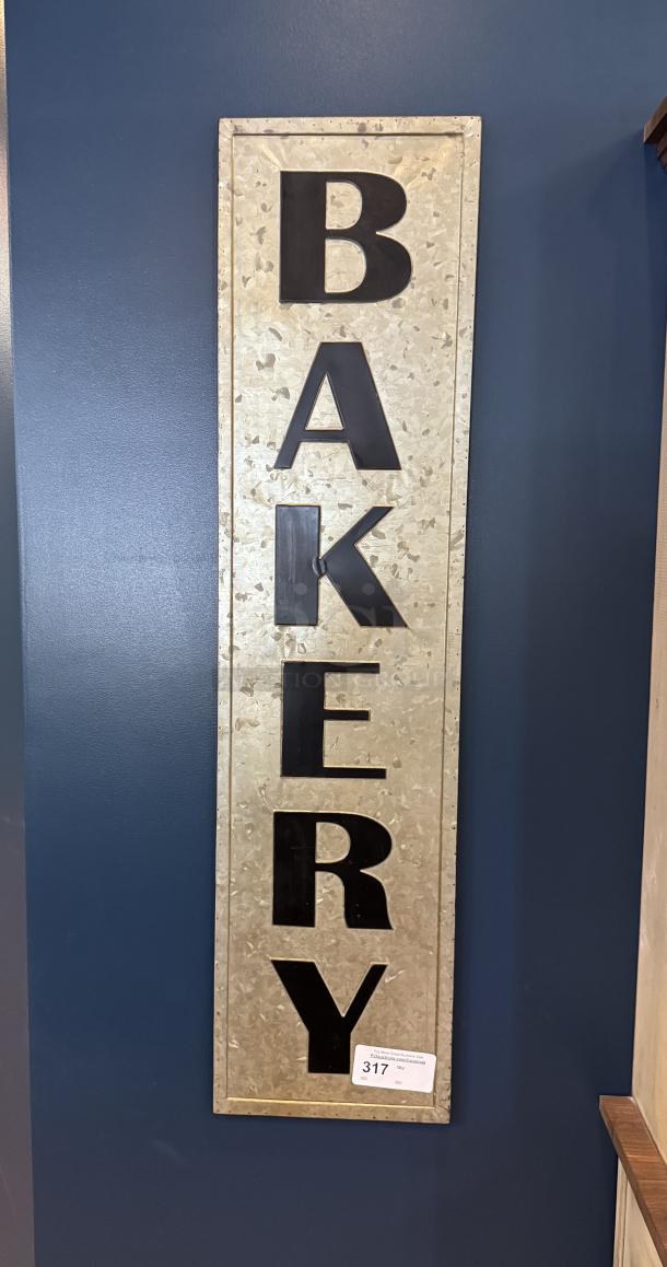 Tin bakery wall sign with black lettering on a galvanized metal background. Condition appears good, with auction tag labeled "317."