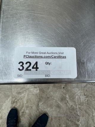 Stainless steel table with undershelf, auction tag 324 visible. Durable, ideal for kitchen or restaurant use.