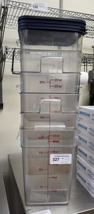 Stack of six 22 Qt. square containers, clear with volume markings and four dark lids. Auction tag notes "Qty: x4 Lids, x6 Bid."