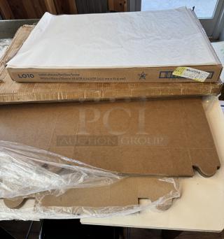 Assorted bakery supplies including boxes, parchment paper (1,000 sheets, white, 16.3x24.3 in), and bags. New condition.