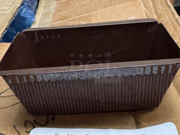 Disposable mini loaf pan with ribbed texture, brown paper material, clean condition. Ideal for baking small breads.