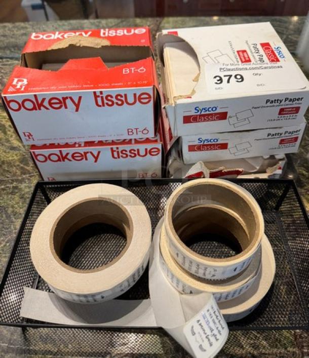 Boxes of bakery tissue and Sysco Classic patty paper, with rolls of adhesive labels, in good condition.