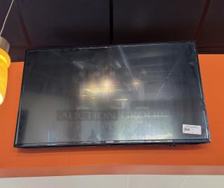 Samsung 52" TV mounted on wall, with remote. Tested and working, includes a visible auction label with number 384.