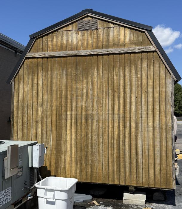 Wood barn with metal roof, featuring vertical wood siding. Equipped with ventilation vent and two fixed windows. Good condition.