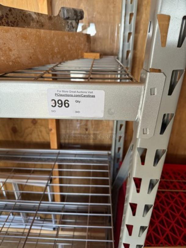 Metal rack with 4 wire shelves, sturdy construction, silver finish. Label: Auction tag with item number 396.
