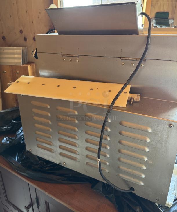 Somerset Dough Roller, tested and working, in good condition. Features metal body, power cable, and vented side panel.