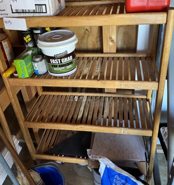 Wooden slat bookcase with 4 shelves, used condition, visible adhesive products on shelves, natural finish.