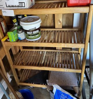 Wooden slat bookcase with 4 shelves, used condition, visible adhesive products on shelves, natural finish.