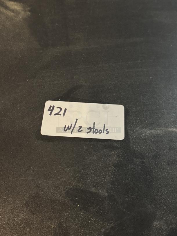 Black round bar height table with two stools, labeled "421 w/2 stools."