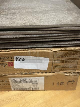 Daltile porcelain floor tiles, 12" x 12", stacked and boxed. Labels show model 1212P1P2, indicating tile specifications and batch.