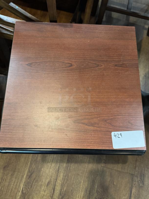 Wooden display table with rich grain pattern, rectangular shape, and sturdy construction. Features a label marked "429."