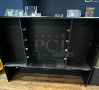 Black display case with three sections, multiple adjustable shelves, and a sturdy wooden construction. Some dust visible.