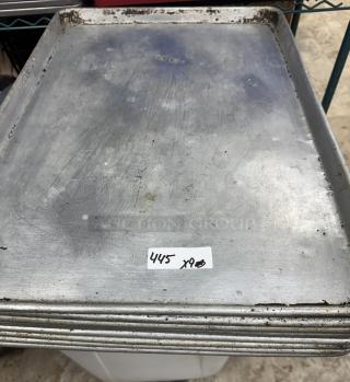 Full-size sheet pans, stack of 9, showing signs of wear. Label reads "445 x9". Suitable for commercial baking.