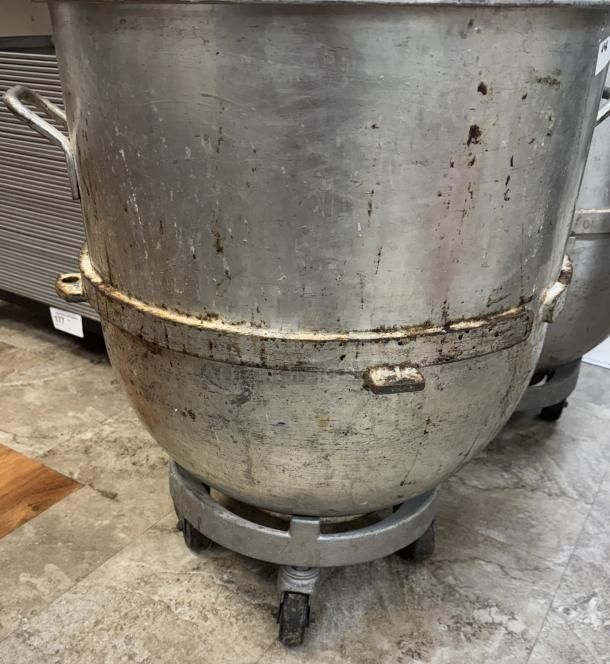 140 Qt. mixing bowl with dollie, pre-owned. Features side handles, some wear and rust spots, on rolling base for mobility.