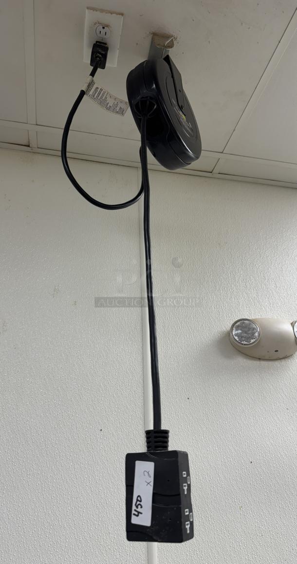 Pro Reel Ceiling Drop Cord, black, mounted on ceiling. Includes retractable cord with plug. Light wear visible.