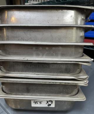 Stack of nine stainless steel half pans, lightly scratched, labeled "455 x 9." Suitable for catering or restaurant use.