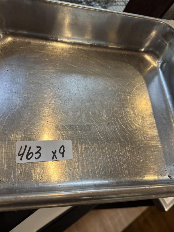 Stainless half-size sheet pan with visible scratches, quantity 9. Labeled "463 x9," indicating lot number and count.