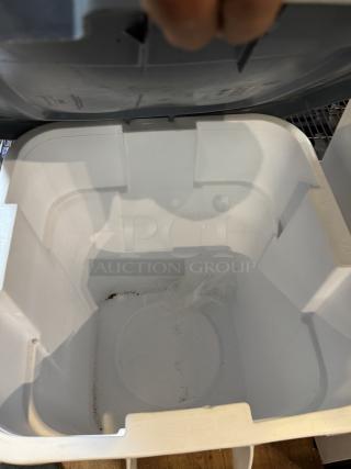 Rubbermaid 28 Gal. dry storage container, white interior, hinged lid, slight wear visible inside, suitable for bulk storage.