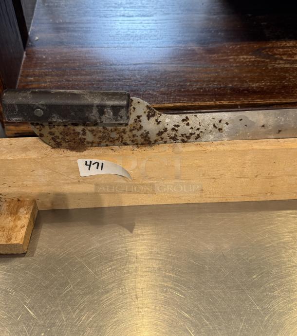 Rusty dough cutter with black handle on wooden stand, item 471 tag visible.