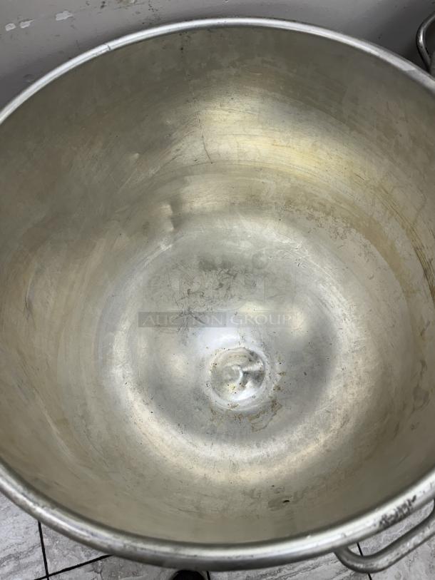 140 Qt. metal mixing bowl with dollie, used condition, shows signs of wear and use, ideal for commercial kitchens.