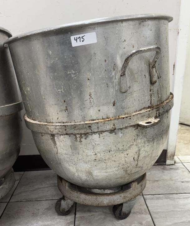 140 Qt. stainless steel mixing bowl with dollie, noticeable wear and patina, number label "475" attached.