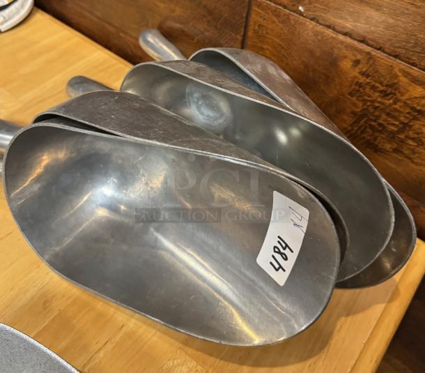 Set of four metal scoops: one 38 oz and three 58 oz. Lightly used condition, marked with tag number 484.