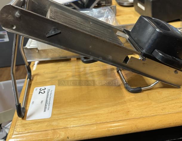 Jaccard mandolin slicer with attachments, metallic finish, slightly used. Auction tag showing lot 32.