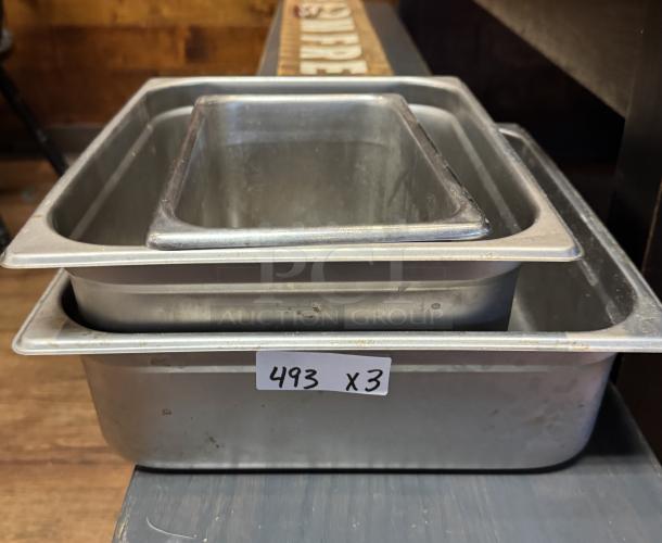 Assorted Vollrath and Update stainless steel pans, three pieces, various sizes, auction tag "493 x 3" visible, good condition.