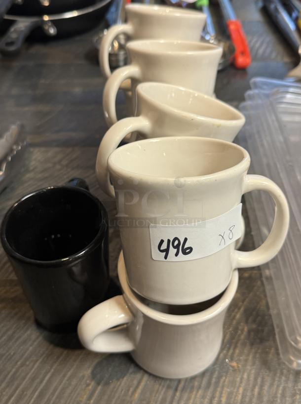 Eight coffee mugs in white and black with a label marked "496 x 8." Mugs appear in good condition.