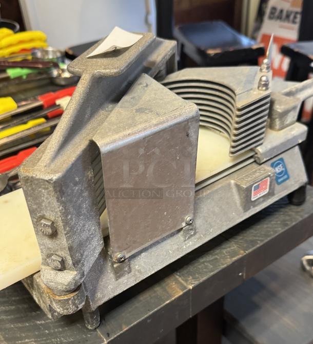 Nemco slicer with multiple blades, metal construction, and NSF certification. Shows signs of wear, includes U.S. flag marking.