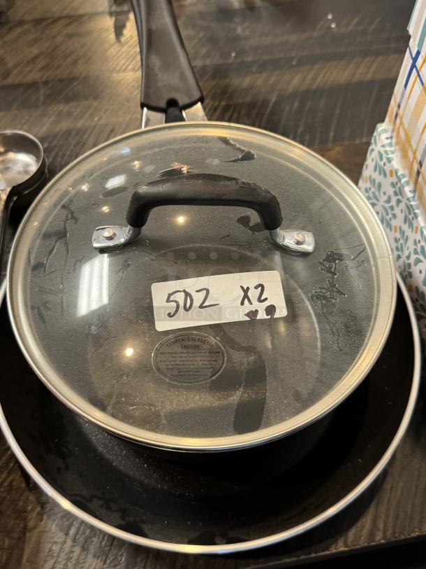 Tramontina 10" frying pan and 2.75 Qt. sauce pan with lid. Features glass lid, black handle. Slightly used condition. Item tag: 502 x2.