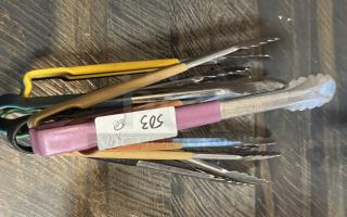 Assorted metal tongs set, seven pieces, various colored handles, good condition, visible label reads "503."