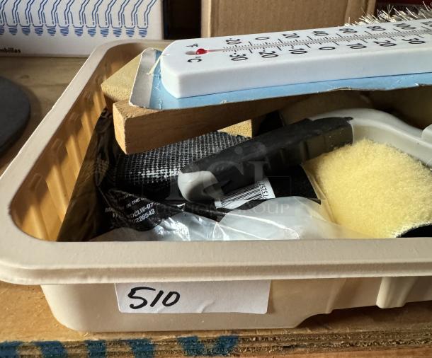 Assorted painting supplies with brushes, rollers, and a new thermometer in a tray labeled "510." Items are unused.
