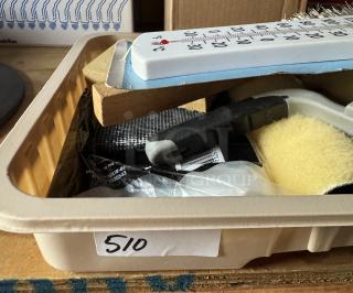 Assorted painting supplies with brushes, rollers, and a new thermometer in a tray labeled "510." Items are unused.