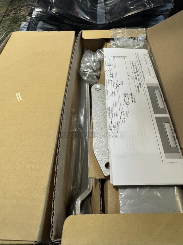 Alt text: "Global Door Controls TC611-Al closer, new in box with installation guide and hardware, auction item."