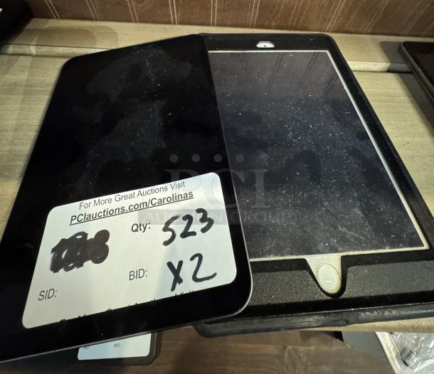 Apple iPad Mini, tested and working, two units for auction. Includes visible sticker with auction details.
