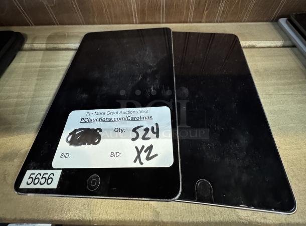 Apple Mini iPad, tested and working. Includes two units. Visible auction label with item code 5656.