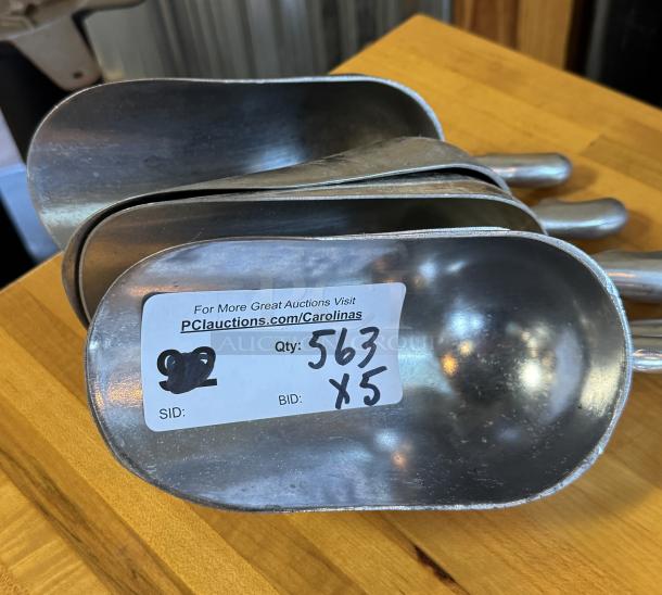 Set of five 24 oz metal scoops, shown stacked. Auction label indicates quantity 5, lot number 563. Durable, good condition.