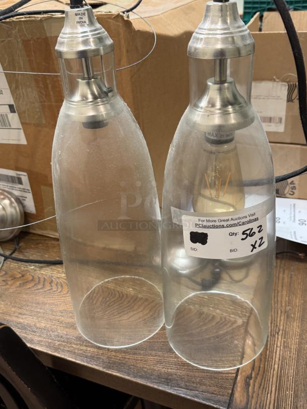 Pair of hanging pendant lights with glass shades and silver metallic fixtures. "Made in India" label visible. Condition appears used.