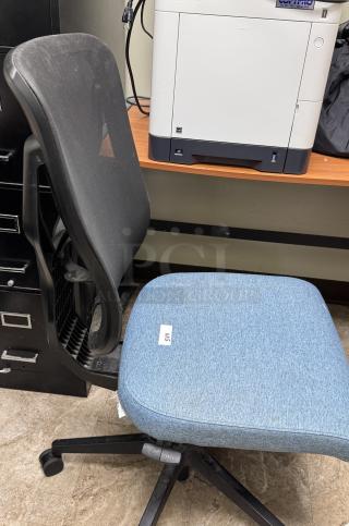 Blue swivel office chair with black mesh back, blue fabric seat, and adjustable height. Visible label reads "SW3". Good condition.