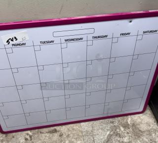 Wall mount monthly planner with pink frame, grid layout for days of the week. Label indicating "543 x2" present. Good condition.