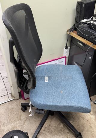 Blue swivel office chair with mesh back, cushioned seat, and adjustable height. Condition appears used. Features caster wheels and a label marked "215".