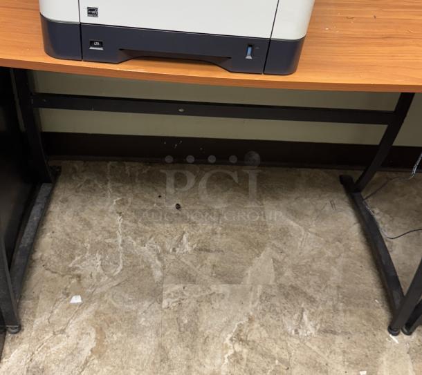 Corner office desk with wood surface and metal legs, printer on top; good condition, ideal for workspace organization.