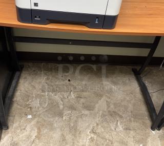 Corner office desk with wood surface and metal legs, printer on top; good condition, ideal for workspace organization.