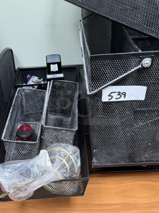 Metal mesh desk organizer with trays and baskets. Includes several compartments, office supplies, and a visible tag marked "539."