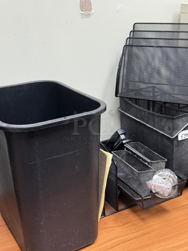 Metal desk organizer with trays and baskets, black mesh design, includes file holder and small compartments. Appears in good condition.