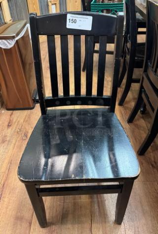 Black wooden dining chair, slatted back, visible wear on seat edges. Lot of 4 chairs, auction label "150" attached.