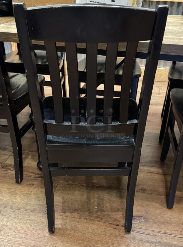 Set of 4 black dining room chairs, wooden, slatted back design, used condition with minor wear.